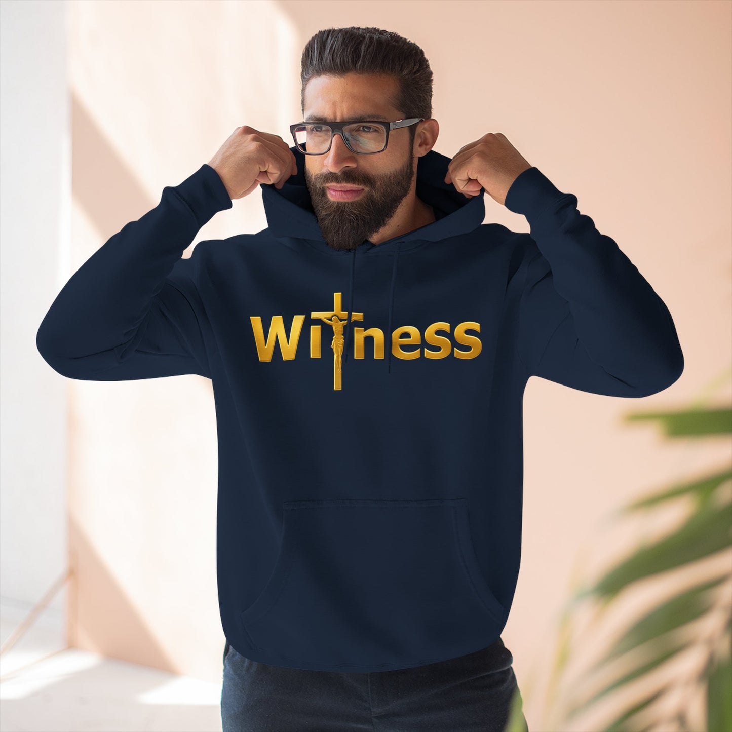 Navy pullover hoodie with gold “Witness” print and cross emblem, hood and front pocket.